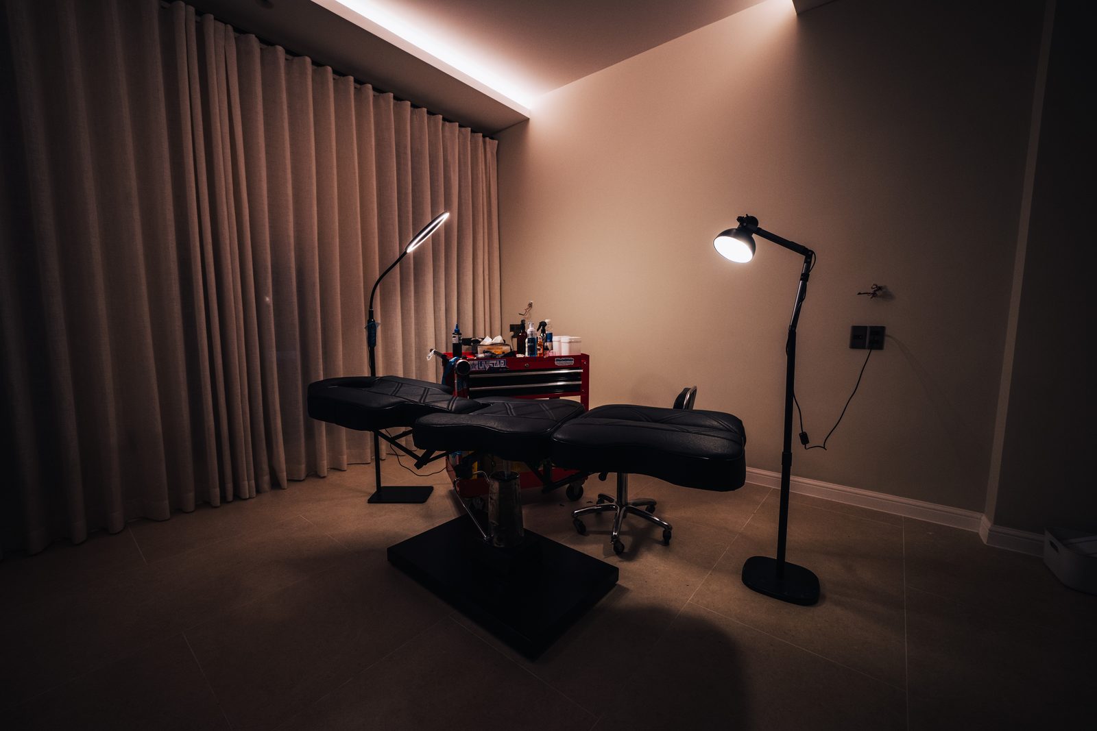 Ink District's private studio room, with an adjustable tattoo bed and soft directional lighting